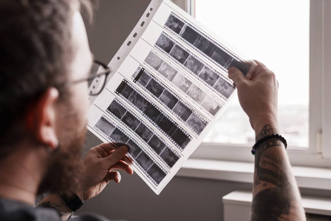 A photographer reviewing contact sheets to build a shortlist